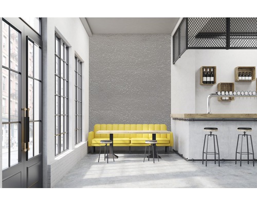 Innenraum mit Bar, gelbem Sofa und Tischen.