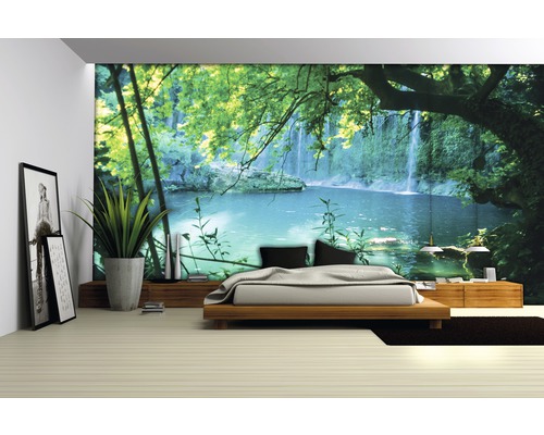 Helles Schlafzimmer mit Fototapete eines Wasserfalls und natürlicher Dekoration.