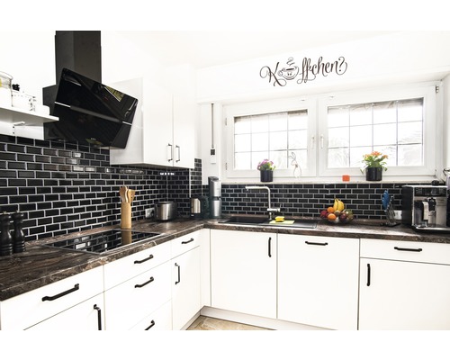 Moderne Küche mit weißen Schränken, dunkler Arbeitsplatte und schwarzen Fliesen