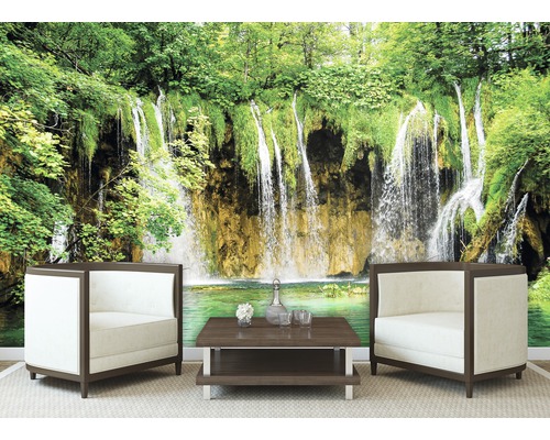 Fototapete mit Wasserfall im grünen Wald, dazu Sessel und Tisch.
