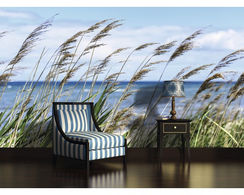 Wohnzimmer mit Sessel, Beistelltisch und Fototapete mit Strandmotiv