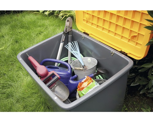 Gartenbox mit Gartengeräten wie Heckenschere, Rechen, Gießkanne und Eimer