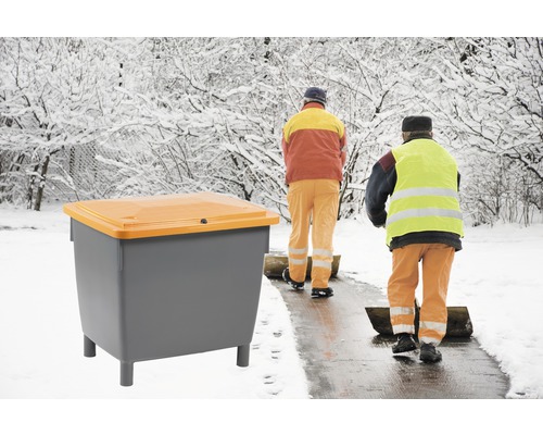 Behälter für Streusalz mit Winterdienstpersonal im Hintergrund