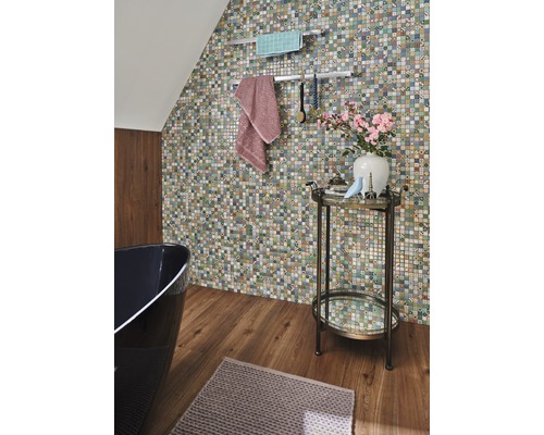 Badezimmer mit Mosaikwand, Badewanne, Handtüchern und Beistelltisch