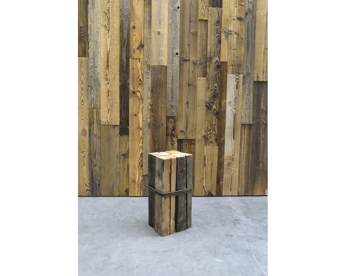 Dekorativer Holzhocker aus Holz vor einer Holzwand