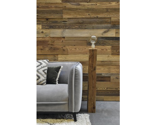 Wohnzimmer mit Holzwand, grauem Sofa und dekorativer Lampe