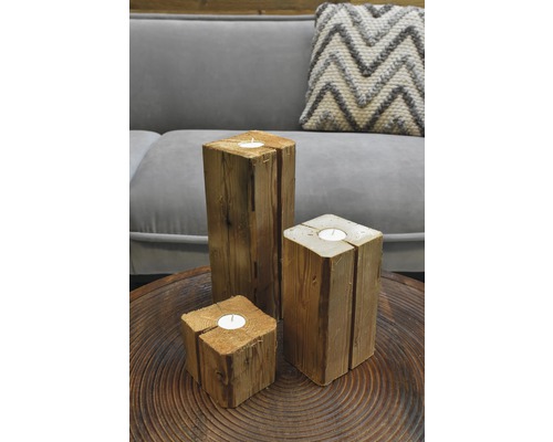 Drei Teelichthalter aus Holz auf einem Tisch