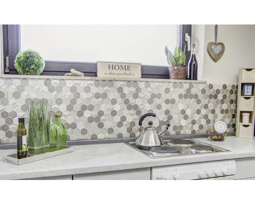 Küchenszene mit Mosaikfliesen im Hexagonmuster, Kochfeld und Dekorationsgegenständen.