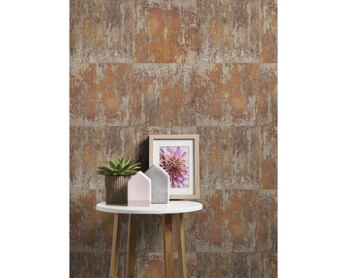 Tapete mit Rostoptik hinter einem Beistelltisch mit Dekoration