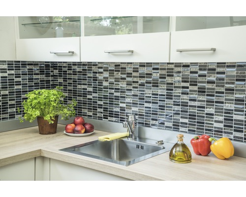 Küchenszene mit Spüle, Armatur, Mosaikfliesen und Lebensmitteln auf der Arbeitsplatte.