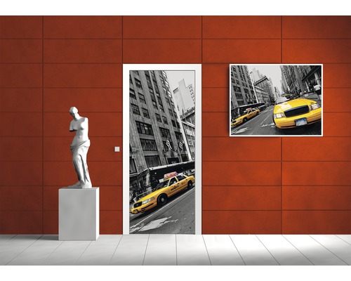 Dekoratives Interieur mit Türposter und Wandbild mit Taxi Motiv sowie einer Skulptur.