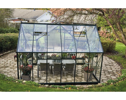 Gewächshaus mit Tisch und Pflanzen im Garten