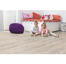 Kinderzimmer mit hellem Holzboden, Sitzbank, Kissen, Spielzeug und zwei spielenden Mädchen