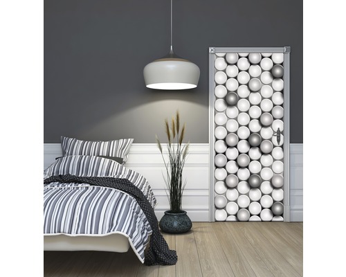Schlafzimmer mit Bett und Türposter mit Kugelmotiv