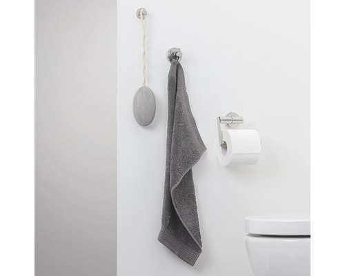 Badezimmer mit Handtuch, Toilettenpapierhalter und Seife an der Wand