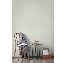 Wohnraum mit Stuhl, Decke, Büchern, Beistelltisch und Bilderrahmen