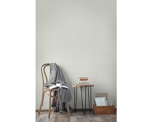 Wohnraum mit Stuhl, Decke, Büchern, Beistelltisch und Bilderrahmen
