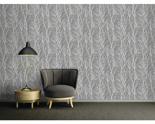 Raumansicht mit grauer Tapete mit Baumdesign, Sessel und Beistelltisch