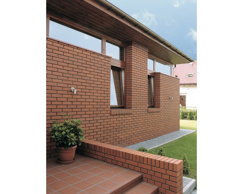 Fassade eines Hauses mit Backsteinen und Fenstern