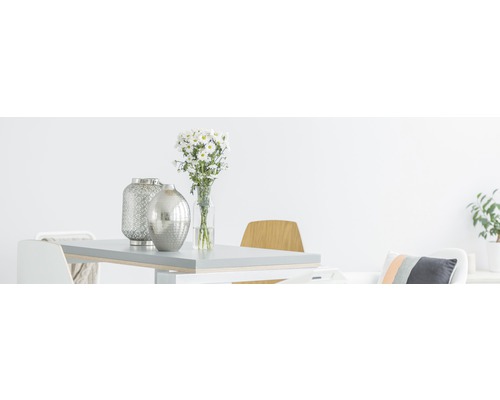 Helles Esszimmer mit Tisch, Stühlen, Blumen und dekorativen Vasen