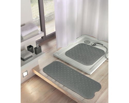 Badezimmer mit Duschwanne und grauen Duschmatten.