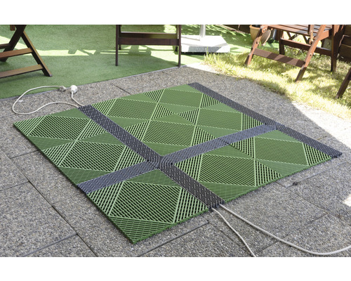 Quadratische, grüne Terrassenfliesen mit grauen Verbindungsstücken auf einem gepflasterten Untergrund im Außenbereich