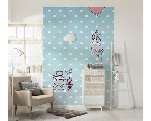 Kinderzimmer mit Winnie Puuh Tapete, Sessel und Kommode für eine freundliche Atmosphäre.