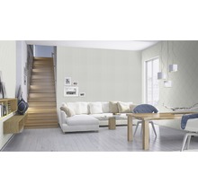 Heller Wohnraum mit Treppe, Sofa, Esstisch und gemusterter Tapete
