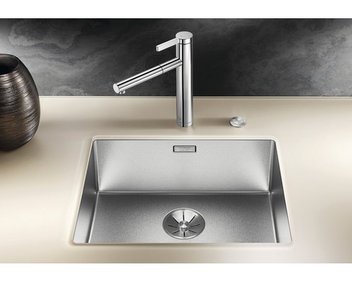 Spüle aus Edelstahl mit Wasserhahn auf einer Arbeitsplatte