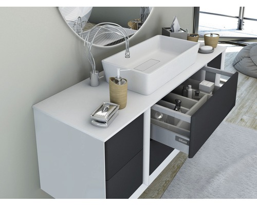 Modernes Badezimmer mit Waschbecken, Unterschrank und offenem Schubfach zur Aufbewahrung von Badutensilien.