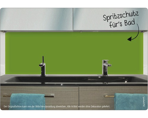 Badezimmer mit einem grünen Spritzschutz hinter dem Waschbecken.