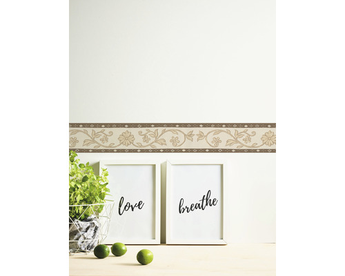 Zimmer mit floraler Bordüre und Dekorationsgegenständen.