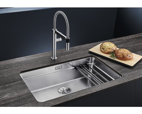 Edelstahlspüle mit Armatur und Schneidebrett auf einer Arbeitsplatte