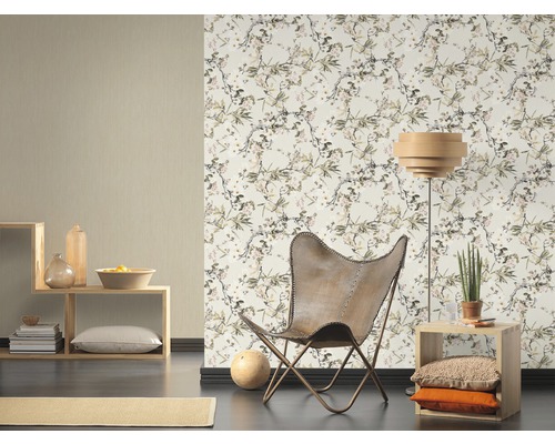 Wohnzimmer mit gemusterter Tapete, Sessel und Holzregalen