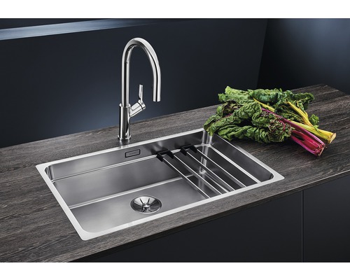 Edelstahlspüle mit Abtropfgestell und Armatur auf einer Arbeitsplatte