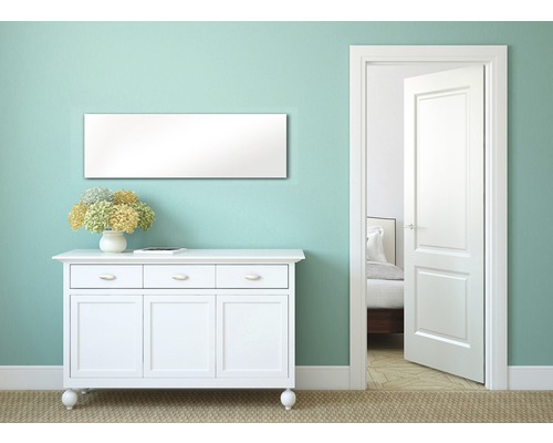 Heller Raum mit Kommode, Spiegel und geöffneter Tür