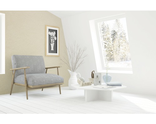 Helles Wohnzimmer mit Sessel, Tisch und Dekorationsgegenständen.