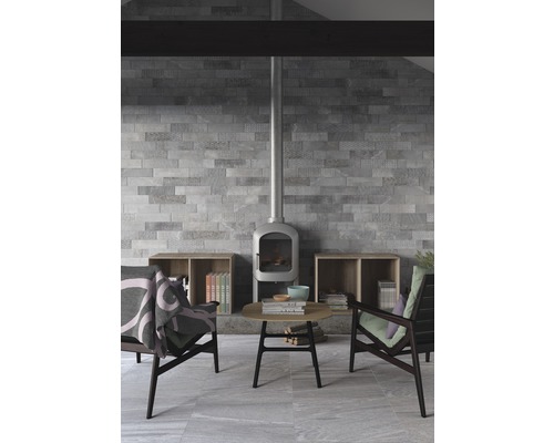 Heller Raum mit Kaminofen, Fliesenwand und Sitzgelegenheiten