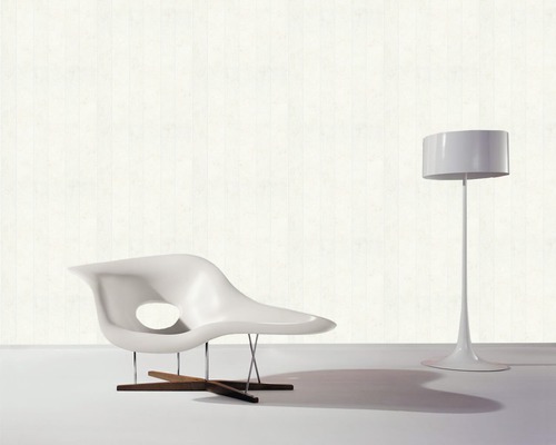 Modernes Interieur mit weißem Sessel und Stehlampe vor einer Wand mit Holzpaneelen