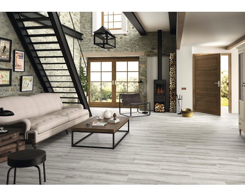 Wohnzimmer mit Sofa, Kamin, Treppe und Holzbodenfliesen