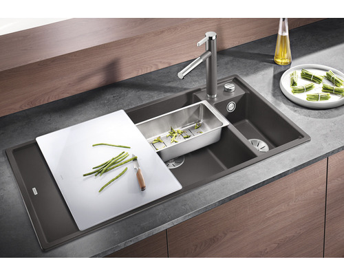 Küchenspüle mit Abtropfschale, Schneidebrett und Armatur auf einer Küchentheke.