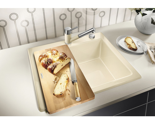 Küchenspüle mit Schneidebrett und Armatur auf einer Küchentheke.