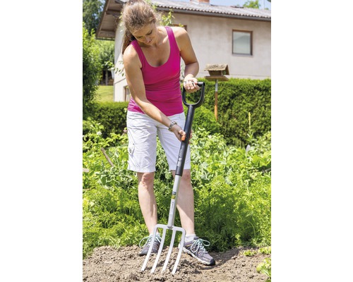 Frau arbeitet mit einer Grabegabel im Garten