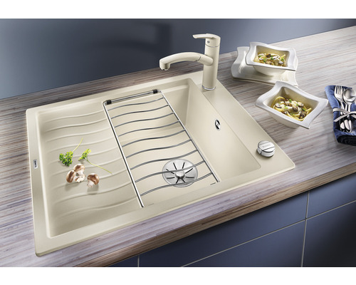 Spüle mit Abtropffläche, Abtropfgitter und Küchenarmatur auf einer Küchentheke mit zwei Schalen Pasta