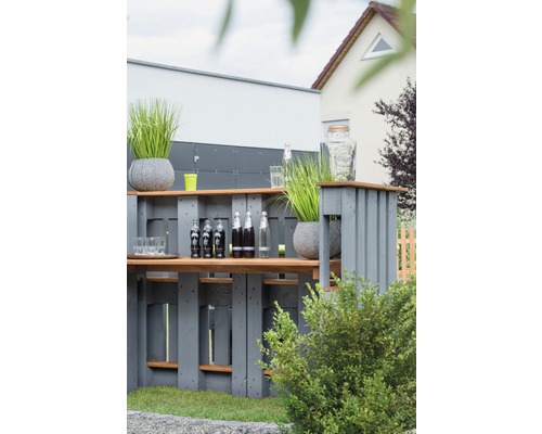 Außenbereich mit einer Bar aus Holzpaletten, Getränken und Dekorationen.