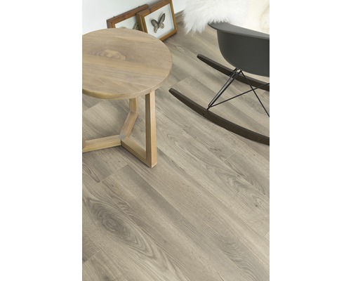 Heller Raum mit Holzboden, rundem Tisch und Schaukelstuhl