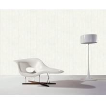 Moderne Inneneinrichtung mit einem Sessel und einer Stehlampe vor einer Tapete mit Holzoptik