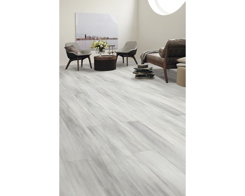 Heller Wohnraum mit Laminatboden in Holzoptik, zwei Stühlen, Sofa und Dekorationen.