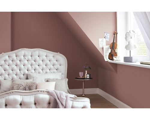 Schlafzimmer mit Bett, Nachttisch und Dekoration an der Wand