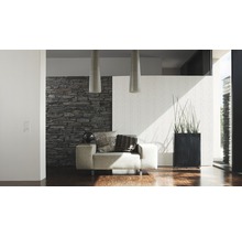 Modernes Wohnzimmer mit Sessel, Steinwand und Zimmerpflanze